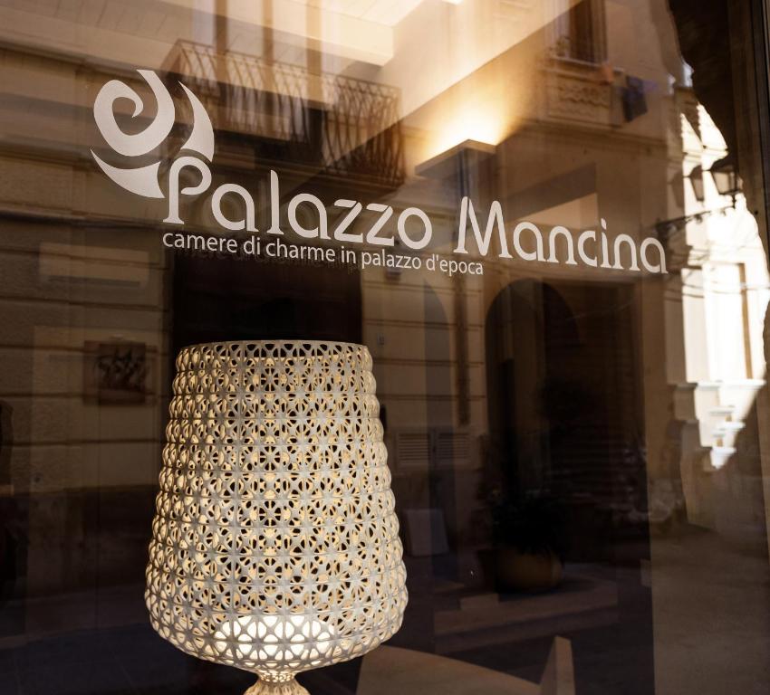 una lámpara de araña en la ventana de una tienda en Palazzo Mancina en Trapani