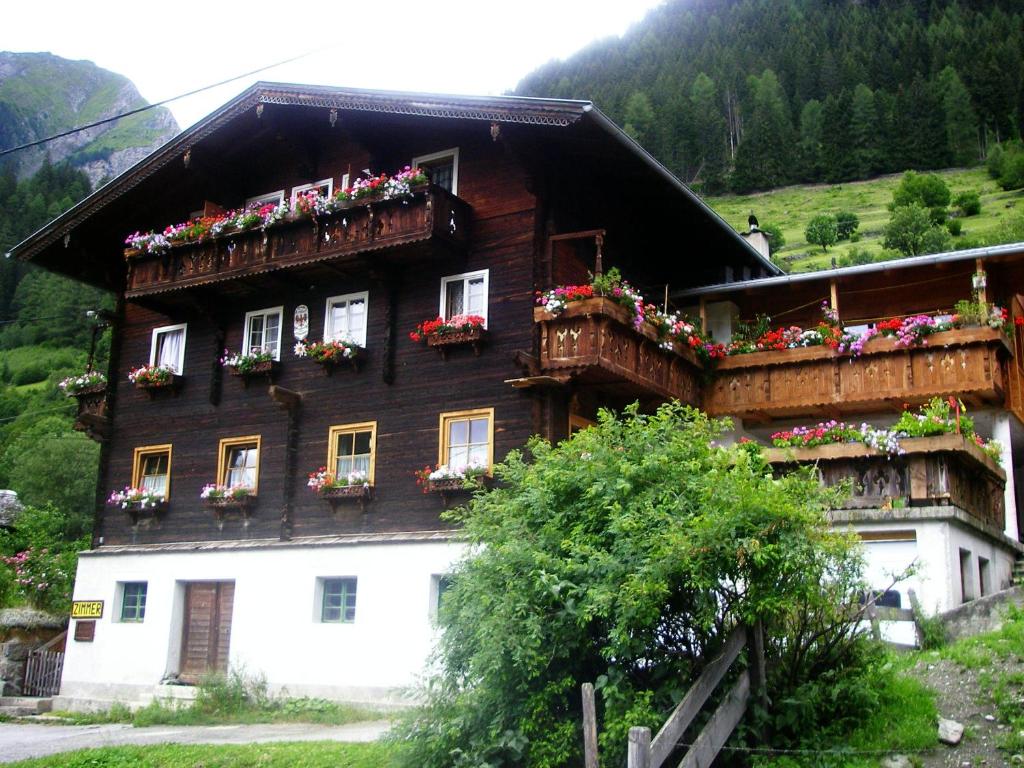 una casa con cajas de flores a un lado. en Stampferhof, en Matrei in Osttirol