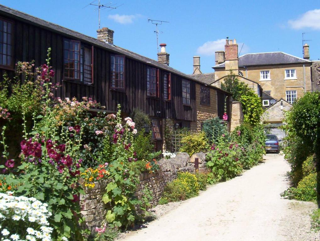 a garden in front of a building with flowers at Centre Chipping Campden - 3 Bedroom Cottage for 5 in Chipping Campden