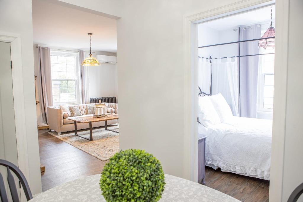 ein Schlafzimmer mit einem Bett und ein Wohnzimmer mit einem Tisch in der Unterkunft Modern Apt Near Downtown Burlington Ideal for long stays - U2 - The Blair in Burlington