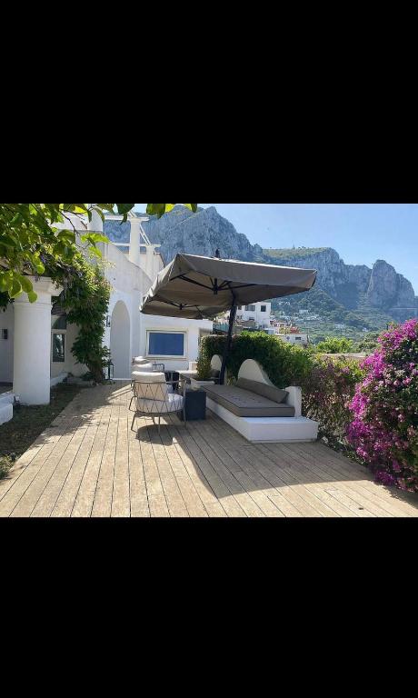 a patio with a couch and an umbrella at Villa Francesca in Capri