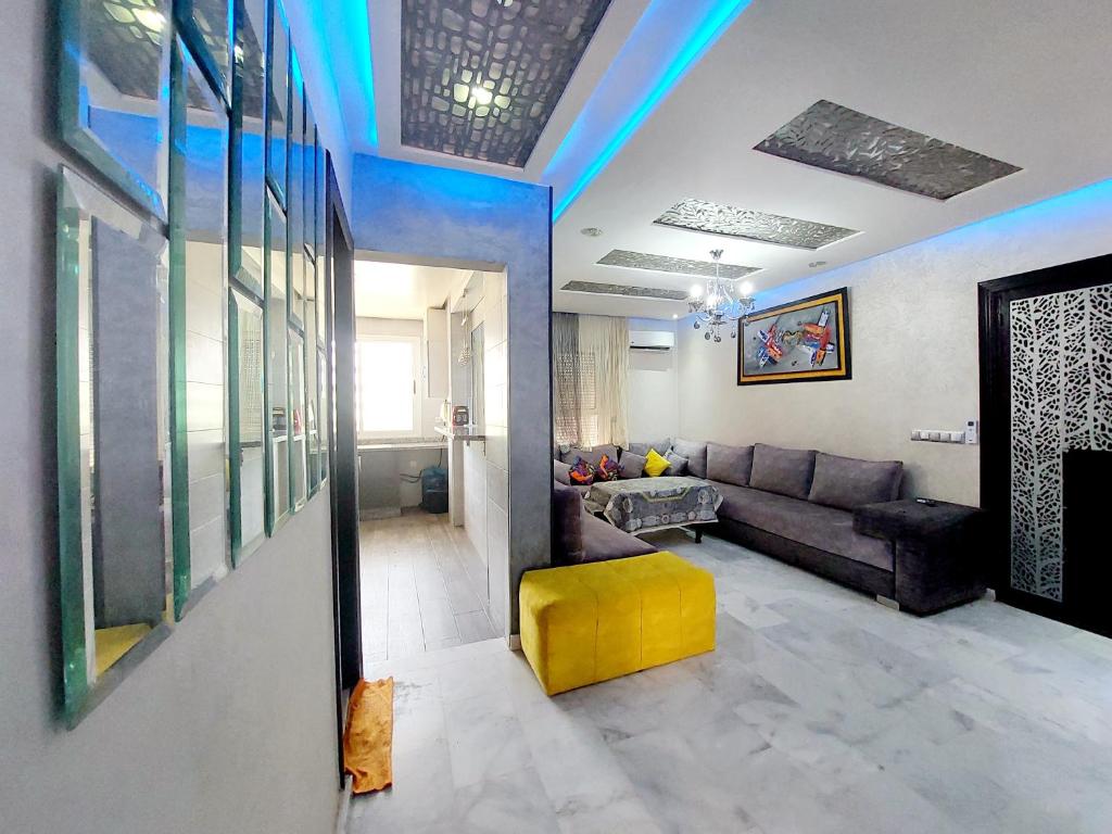 salon z kanapą i żółtym stołkiem w obiekcie Appartement Agadir w mieście Agadir