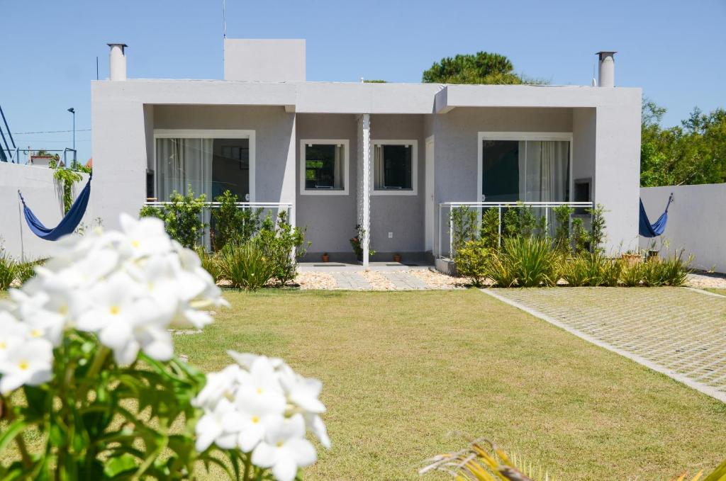 una casa con flores blancas delante de ella en CasaMar Pinheira, en Palhoça