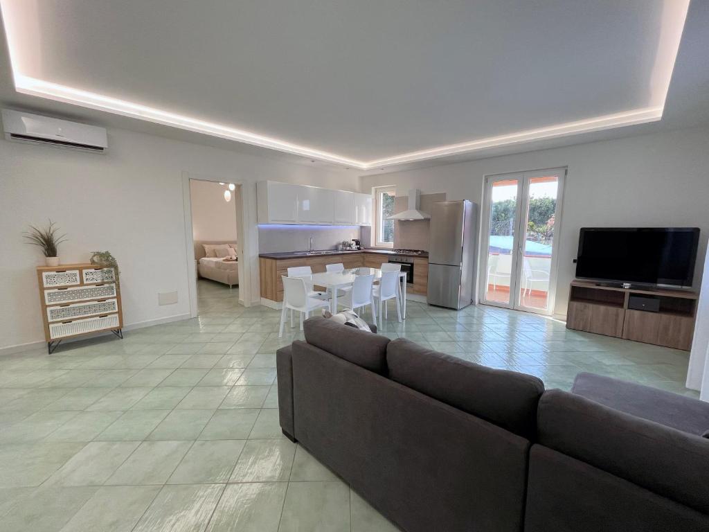 a large living room with a couch and a kitchen at Villa Olea in Procida in Procida