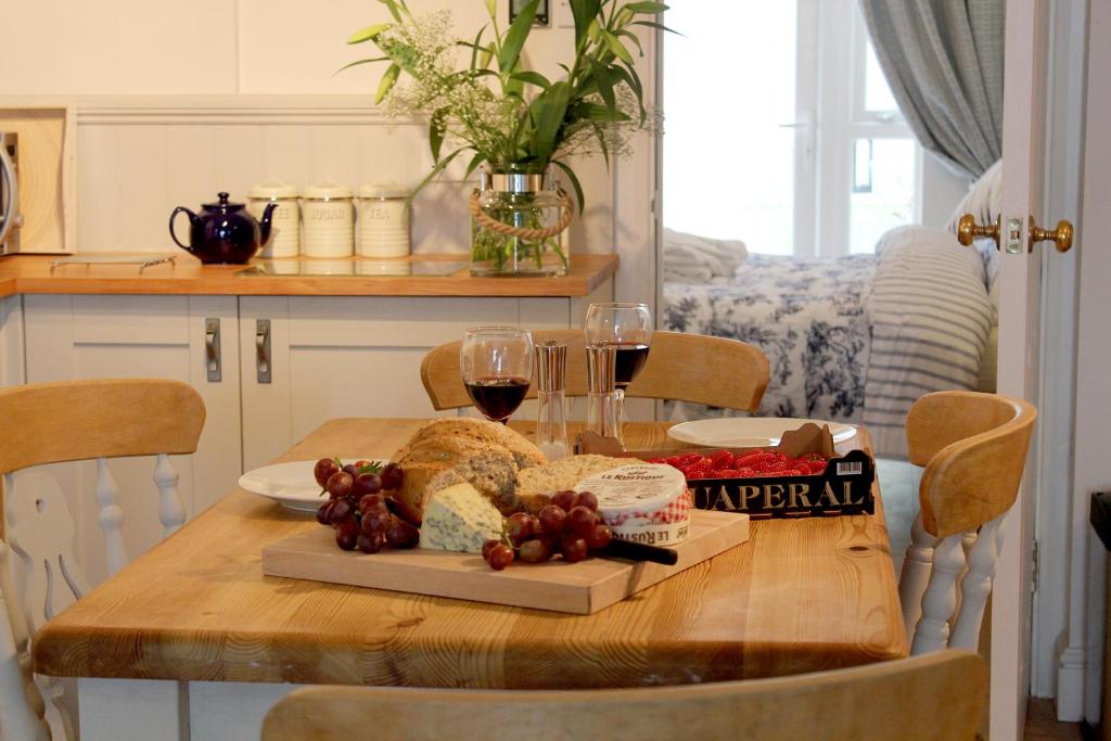 a table with a plate of bread and wine glasses at Beautiful Seaside one bedroom apartment in Shaldon