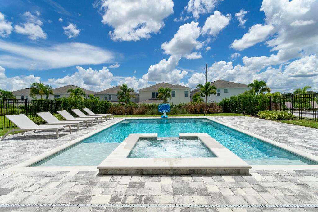 a swimming pool with lounge chairs in a yard at 8-Bed Villa Prv Pool and Game Room Near Disney in Orlando