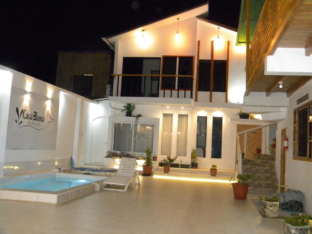 a villa with a swimming pool at night at Casa Blanca Suites in Puerto López