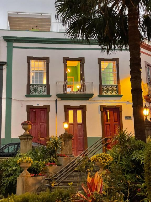 a house with colorful doors and a palm tree at Hostal Bubango in San Andres y Sauces