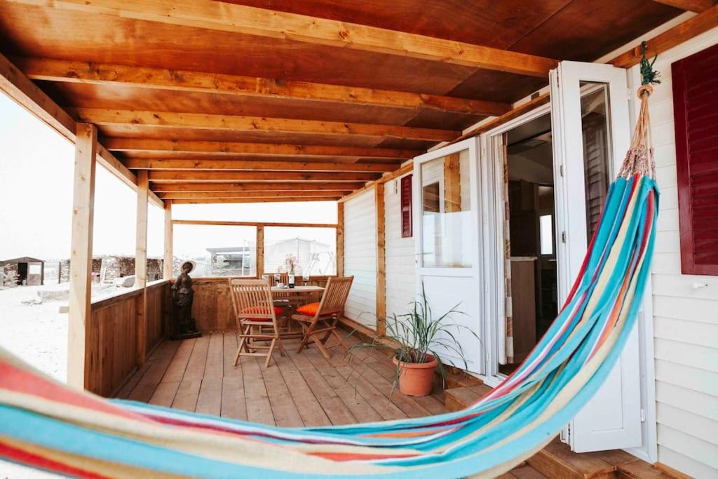 a hammock on the porch of a house at Sunny Tiny House with Sea view in Roque