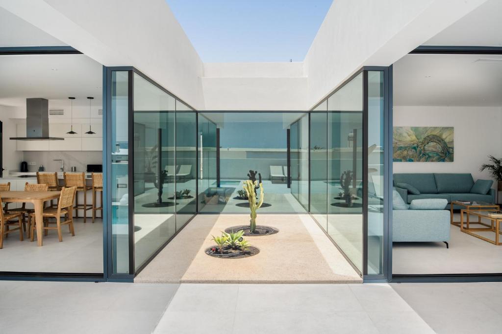 an open living room and dining room with glass walls at TABOIRE by Buenavilla in Puerto Calero