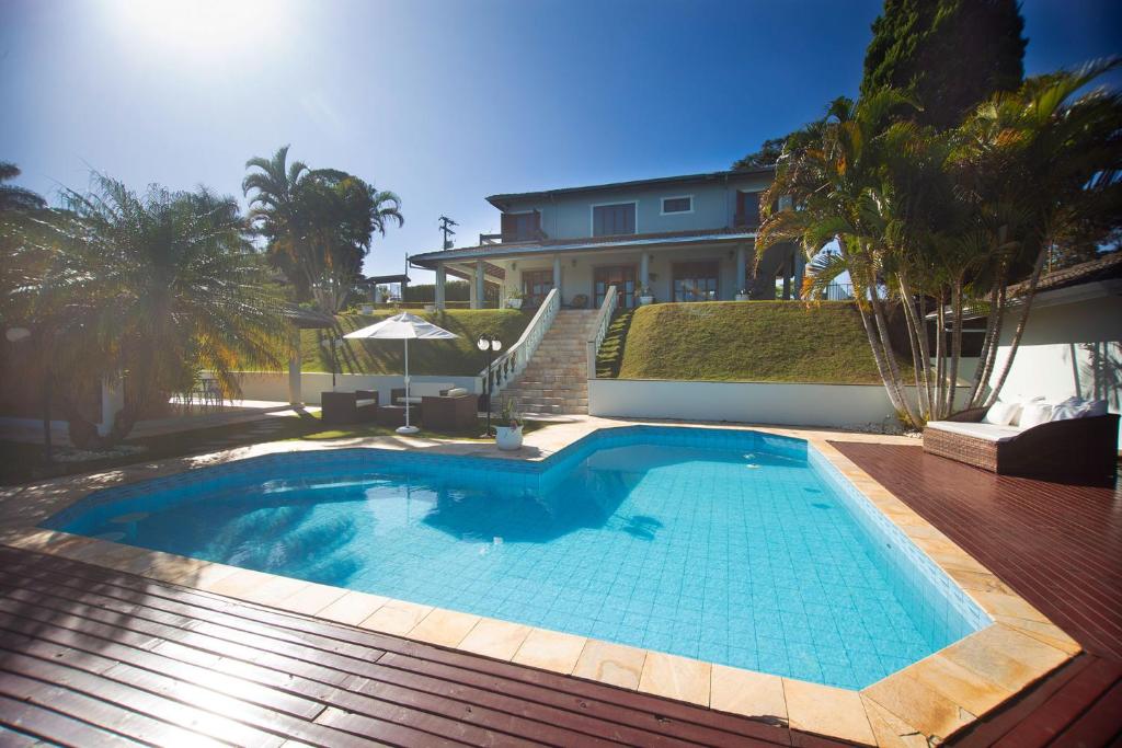 a swimming pool in front of a house at Casa de campo c lazer completo em Joanopolis - SP in Joanópolis