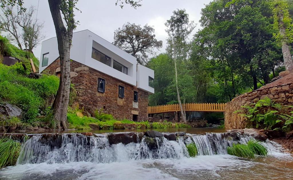 にあるQuinta da Azenhaの川の横に滝のある家