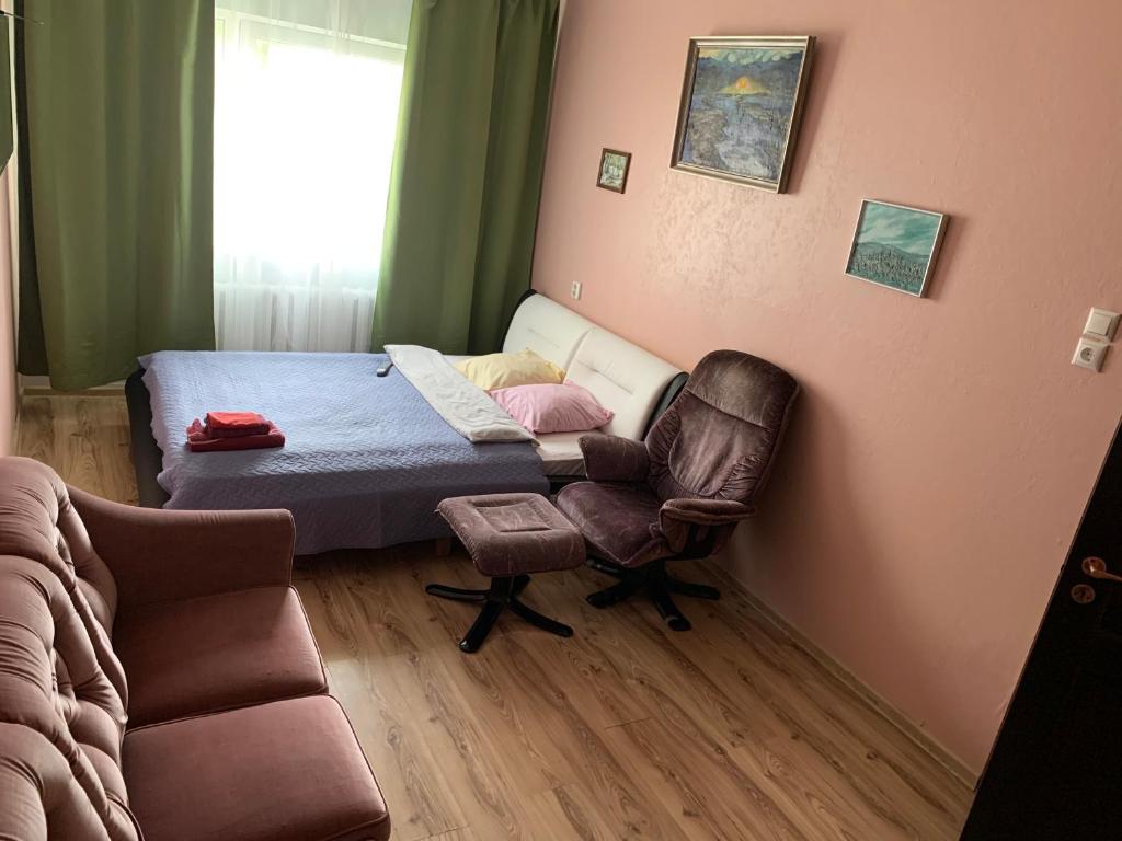 1 dormitorio con 1 cama, 1 silla y 1 sofá en Mõisavahe 30 two big beds 1 single bed en Tartu