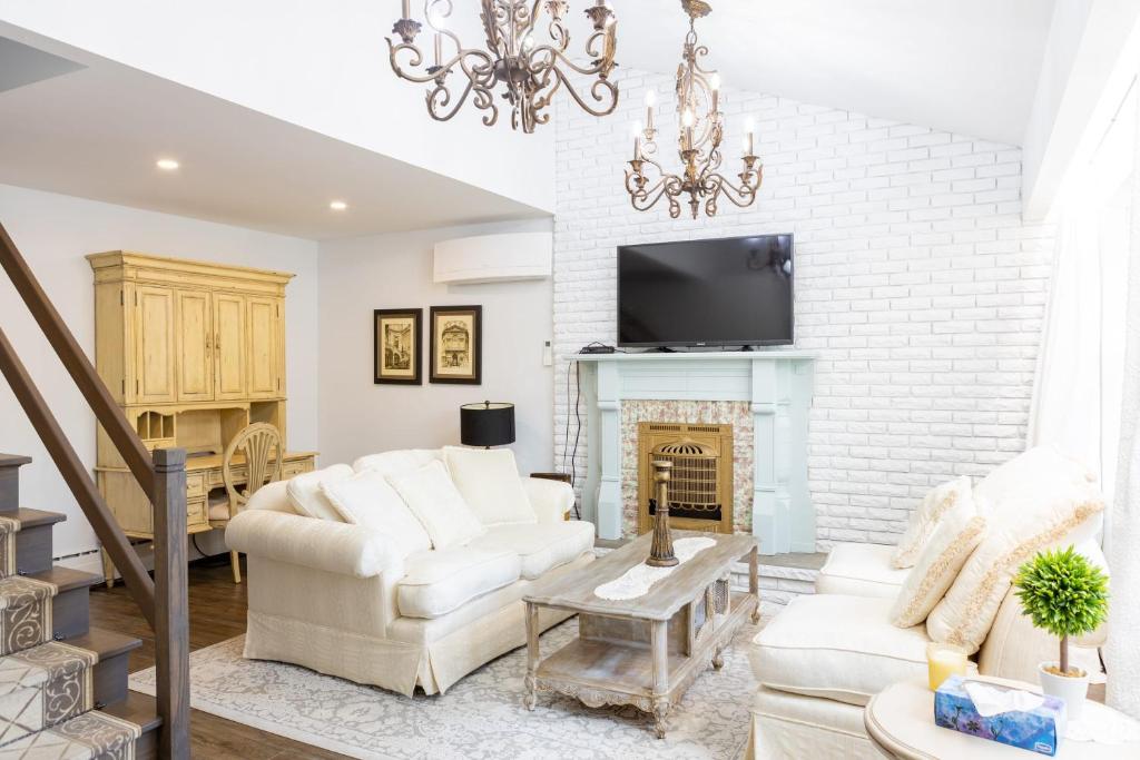 a living room with two white chairs and a fireplace at 3Bdrm Quiet Private Victorian Style Brand New Gorgeous townhouse in Burlington in Burlington