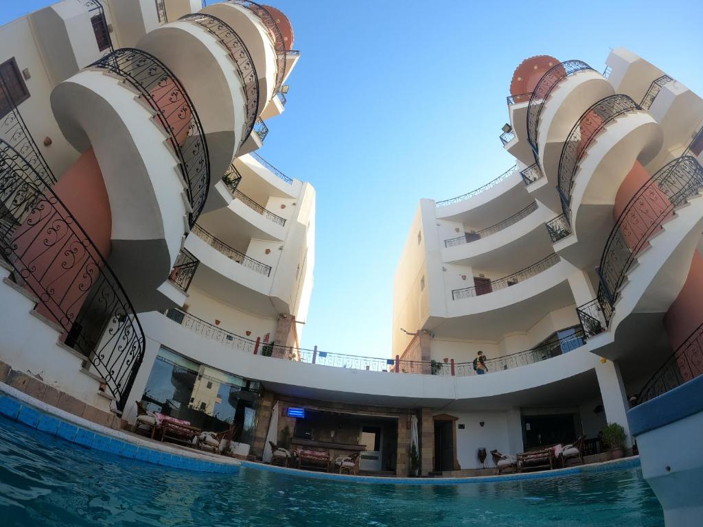 - une vue sur un bâtiment avec piscine dans l'établissement Oasis marsa alam, à Marsa Alam