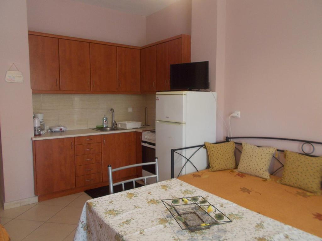 a small kitchen with a table and a white refrigerator at Sapera Evdokia in Filiatra