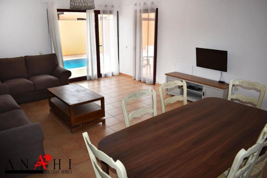 a living room with a table and a couch at Anahi Homes Corralejo- Bicacarera 3 in La Oliva