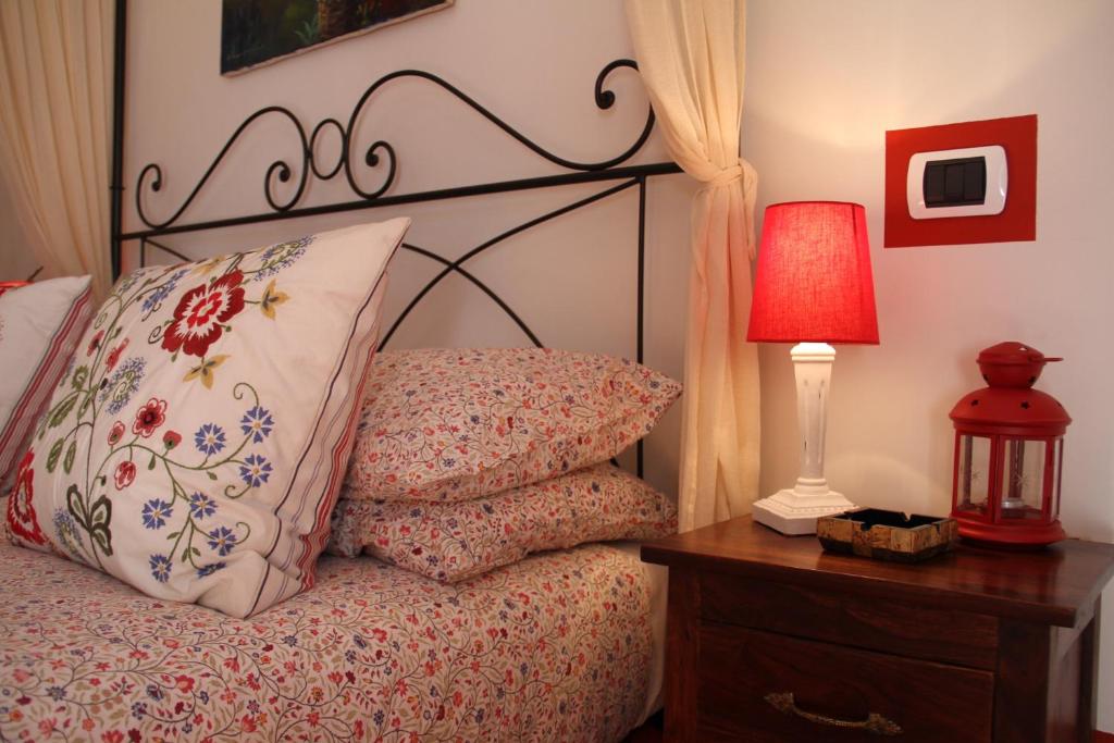 1 dormitorio con 1 cama con lámpara y almohadas en B&B Il casale dei gechi, en Poggio Nativo
