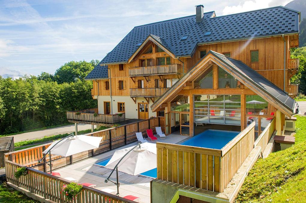 Elle offre une vue sur une maison dotée d'une piscine et d'une terrasse. dans l'établissement Appartement Les Chalets de Belledonne, à Saint-Colomban-des-Villards