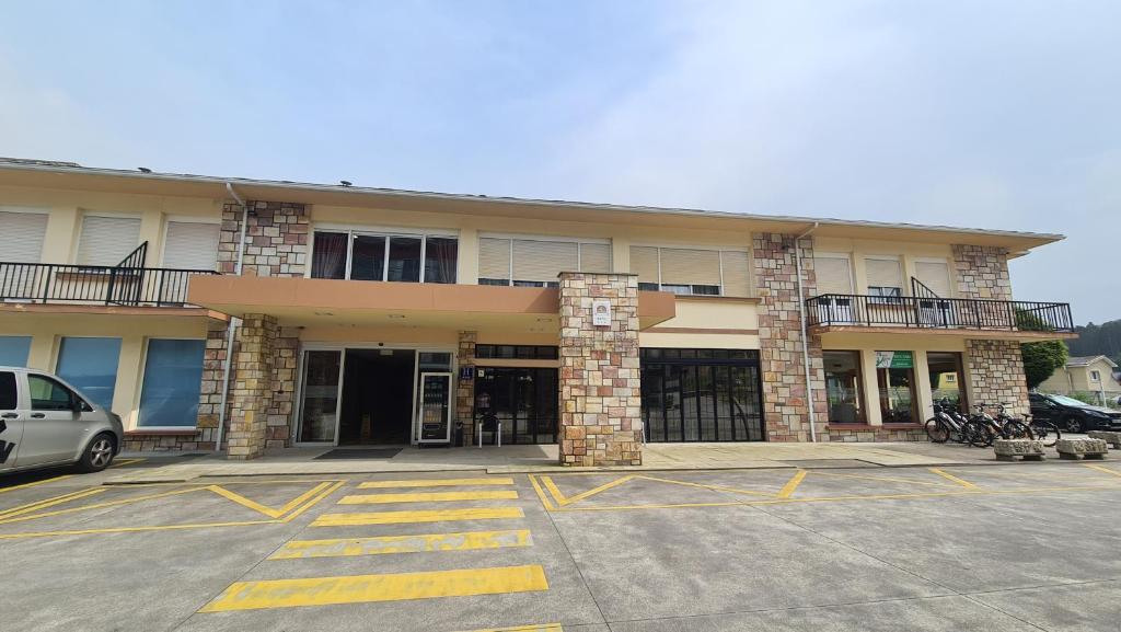 a parking lot in front of a building at Hotel Las Sirenas in Viveiro