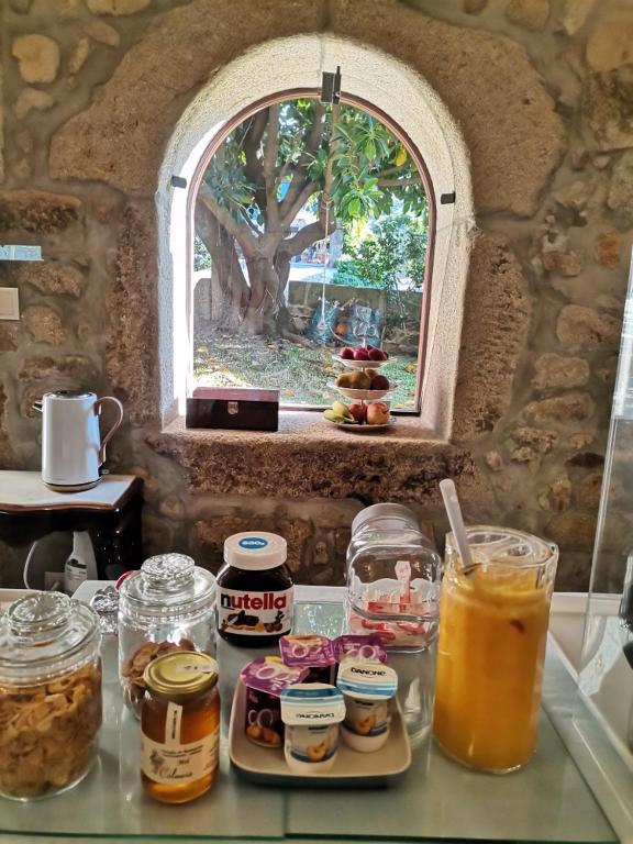 a counter with jars of food and a window at Casa Mindela Farmhouse in Vila do Conde
