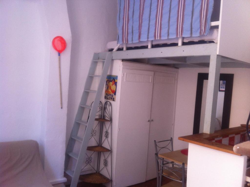Ce lit superposé se trouve dans un dortoir doté d'une échelle et d'un réfrigérateur. dans l'établissement LES PETITS STUDIOS/MEZZANINE du PANIER, à Marseille