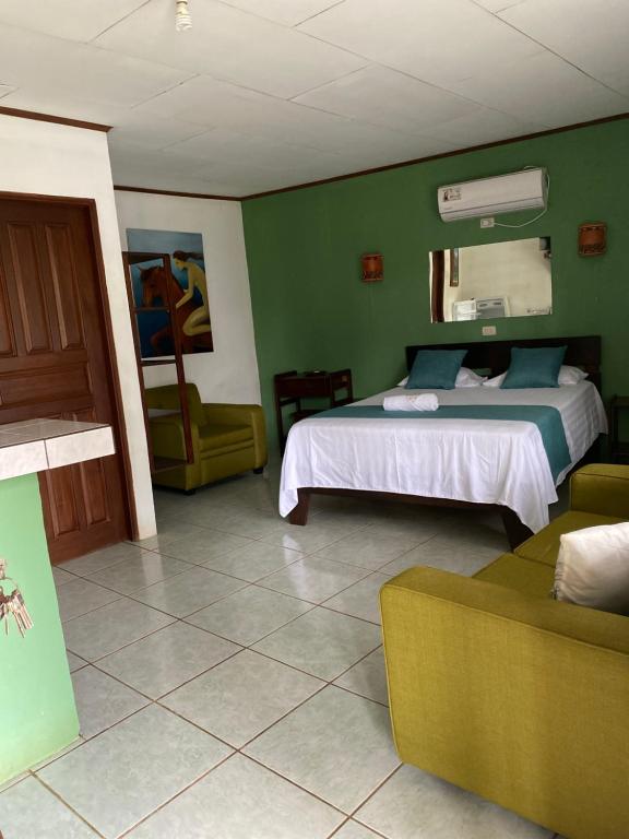 1 dormitorio con cama y pared verde en Hotel Coyote Costa Rica, en San Francisco