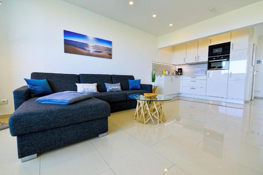 a living room with a couch and a table and a kitchen at Am Sahlenburger Strand AS11 in Cuxhaven