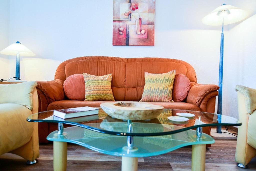 - un salon avec un canapé et une table en verre dans l'établissement Haus Nordseebrandung NB26, à Cuxhaven