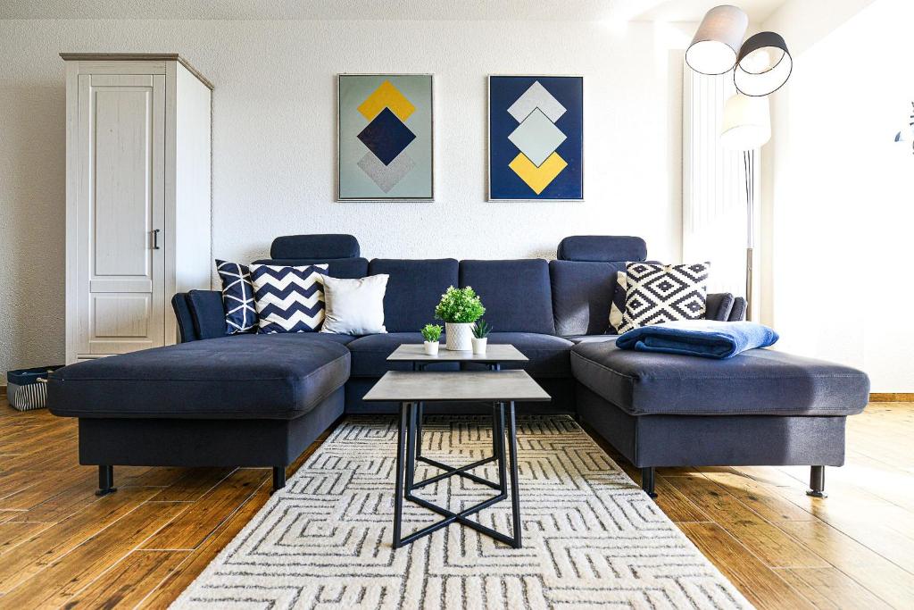 a living room with a blue couch and a table at Strandhochhaus SHC2 in Cuxhaven
