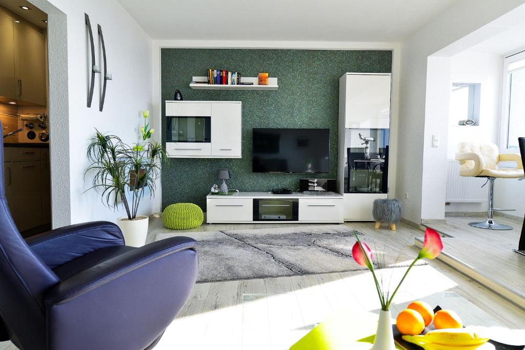 a living room with a blue chair and a television at Strandhochhaus SF10 in Cuxhaven