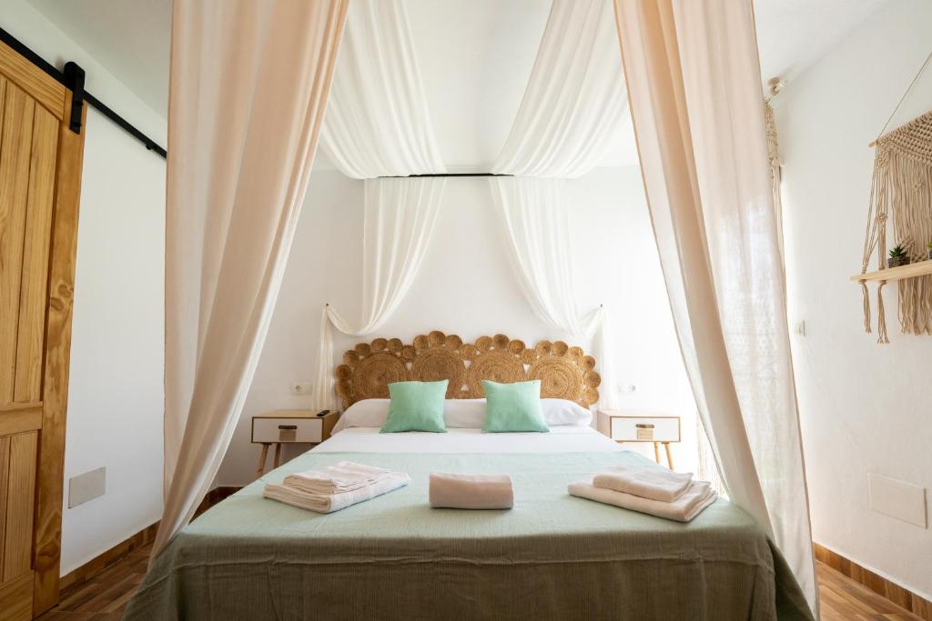 1 dormitorio con 1 cama grande con almohadas verdes en Casa Alegría, en Cómpeta