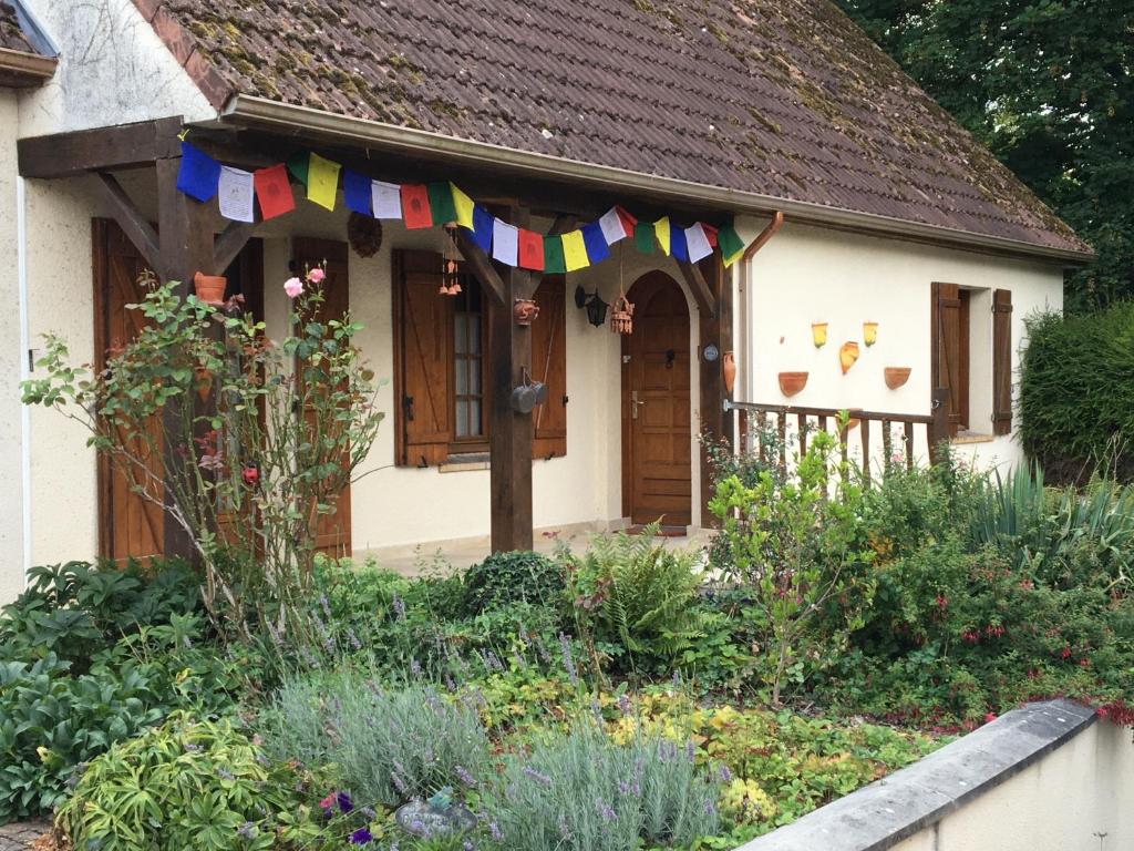 ein Cottage mit Flaggen im Garten in der Unterkunft Un coin de forêt in Courmas