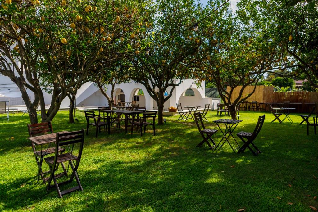 eine Gruppe von Tischen und Stühlen auf einem Feld mit Bäumen in der Unterkunft La Casa sul Faro in Procida