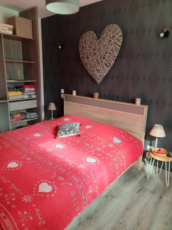 - une chambre avec un lit rouge au cœur du mur dans l'établissement Mon petit paradis, à Berck-sur-Mer