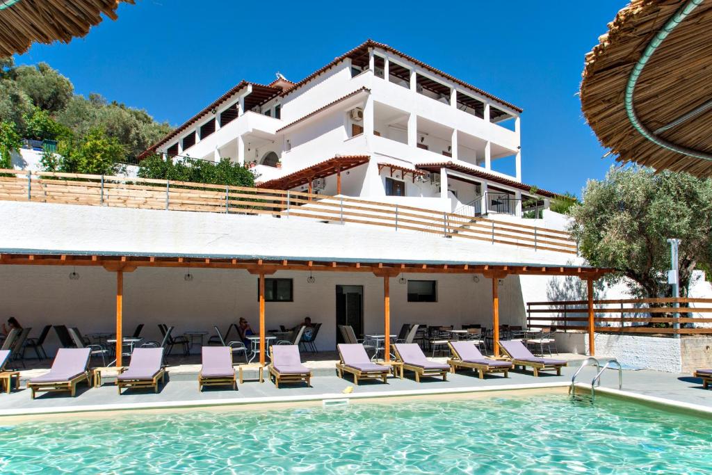 um resort com piscina e espreguiçadeiras em MANGO Skiathos em Skiathos