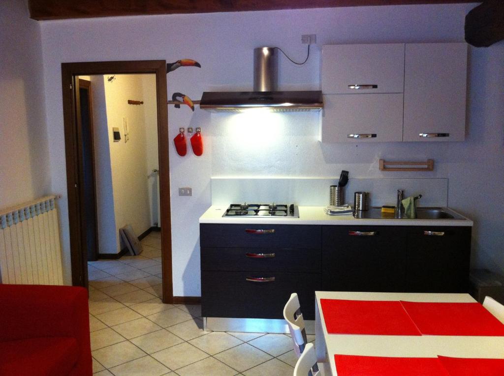 kuchnia z czarnymi szafkami i piekarnikiem w obiekcie -Ortaflats- Appartamento Belvedere w mieście Orta San Giulio