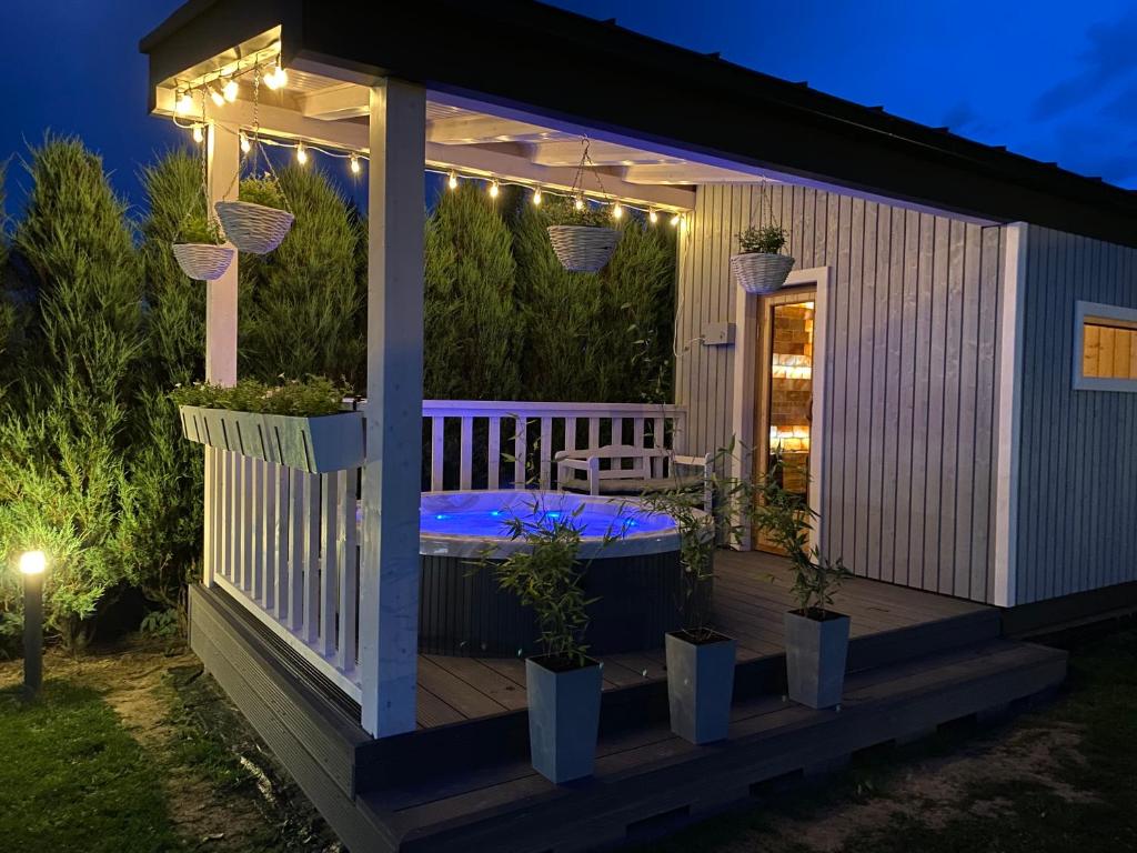 a gazebo with a hot tub on a deck at night at Zielona Kwatera in Polańczyk