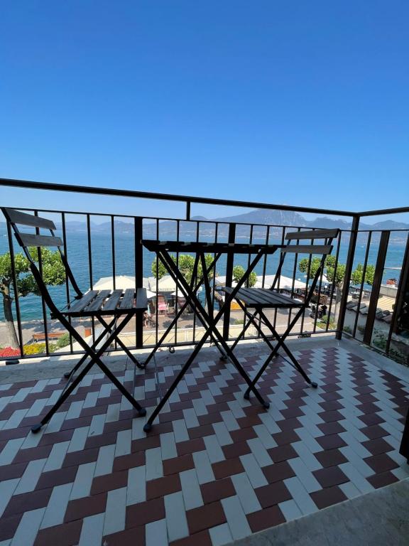 a balcony with two chairs and a view of the beach at Torri Panoramic Apartment in Torri del Benaco