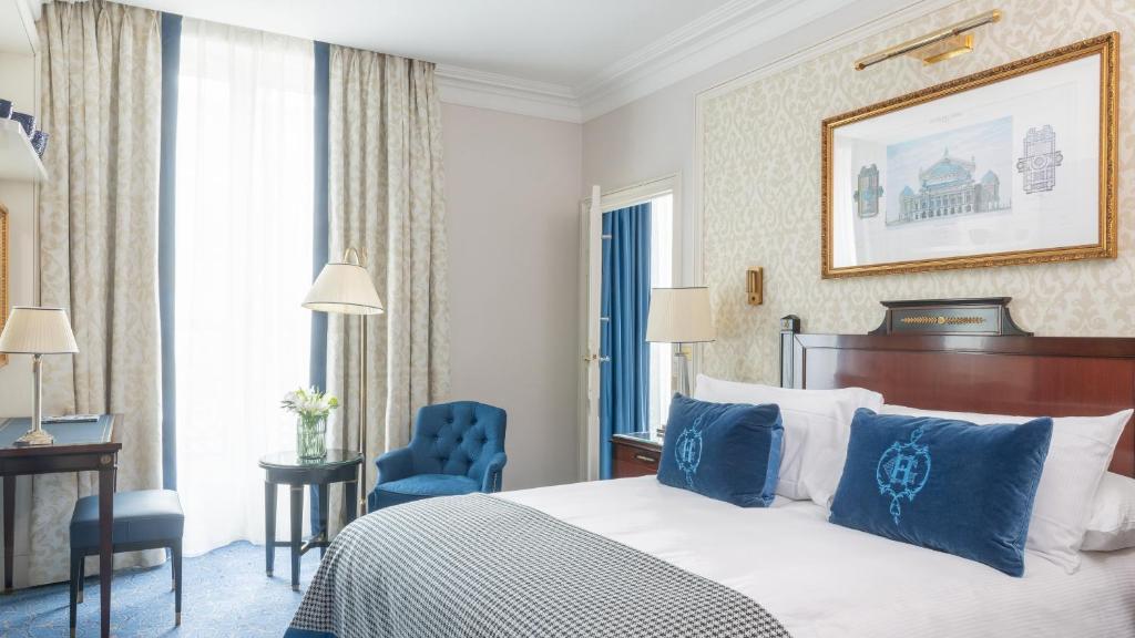 a hotel room with a bed and a blue chair at InterContinental Paris Le Grand by IHG in Paris