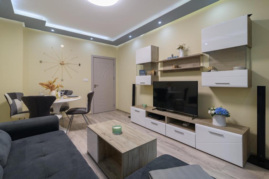 a living room with a couch and a tv and a table at Chayka Comfort Apartment in Varna City