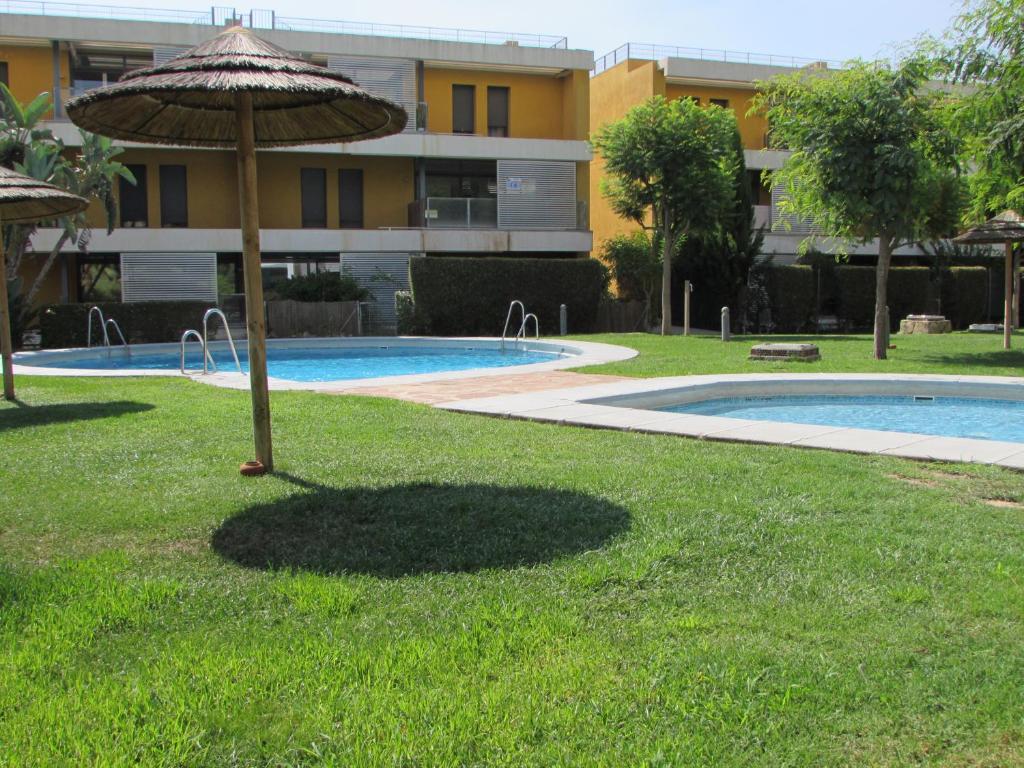 um guarda-sol na relva ao lado de uma piscina em GOLF RESORT APARTMENT em Vera