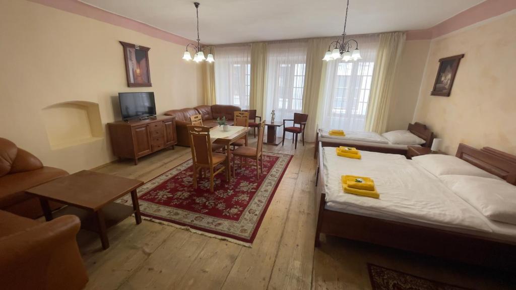 a living room with a bed and a dining room at Pension Pod Radnicí in Český Krumlov