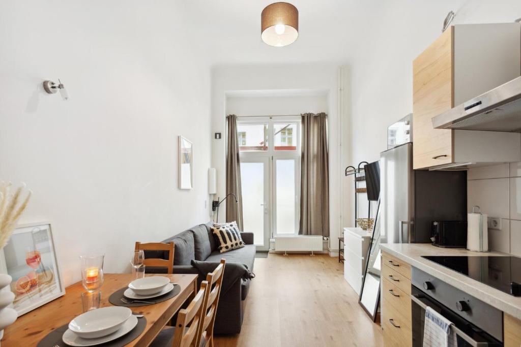 uma cozinha e sala de estar com uma mesa e um sofá em Lux Apartment in Charlottenberg em Berlim