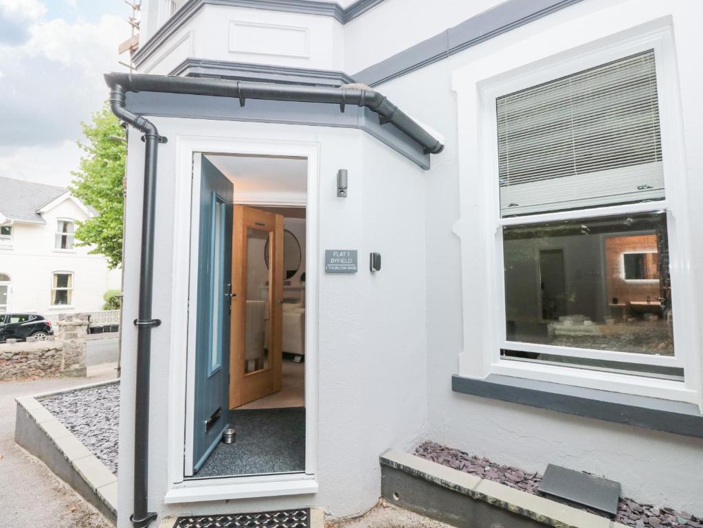 a white house with a blue door and a window at Flat 1 Byfield in Torquay