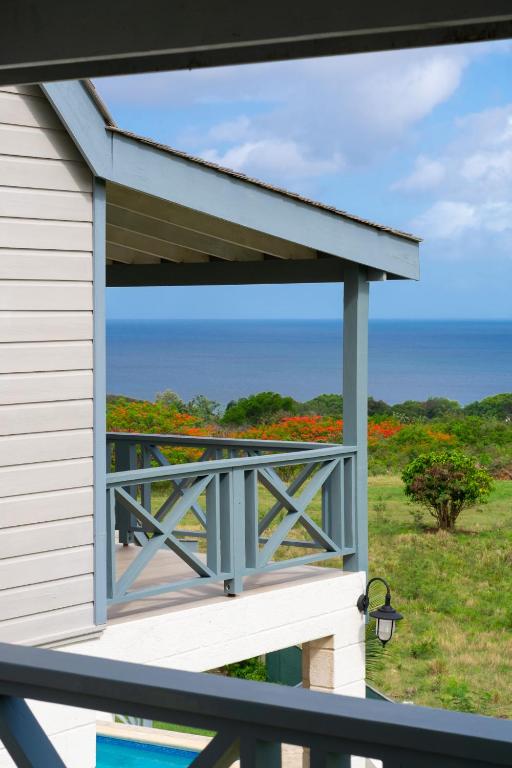 a balcony with a view of the ocean and flowers at West Rock Villas in Saint James