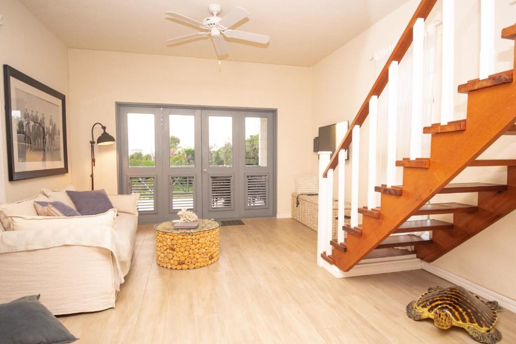 a living room with a white couch and stairs at West Rock Villas in Saint James