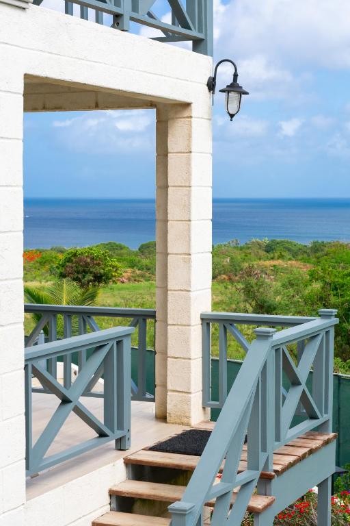 a blue stairway with a view of the ocean at West Rock Villas in Saint James