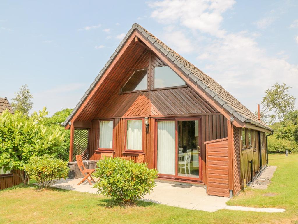 una piccola casa in legno con una grande finestra di Lodge 16 a Camelford