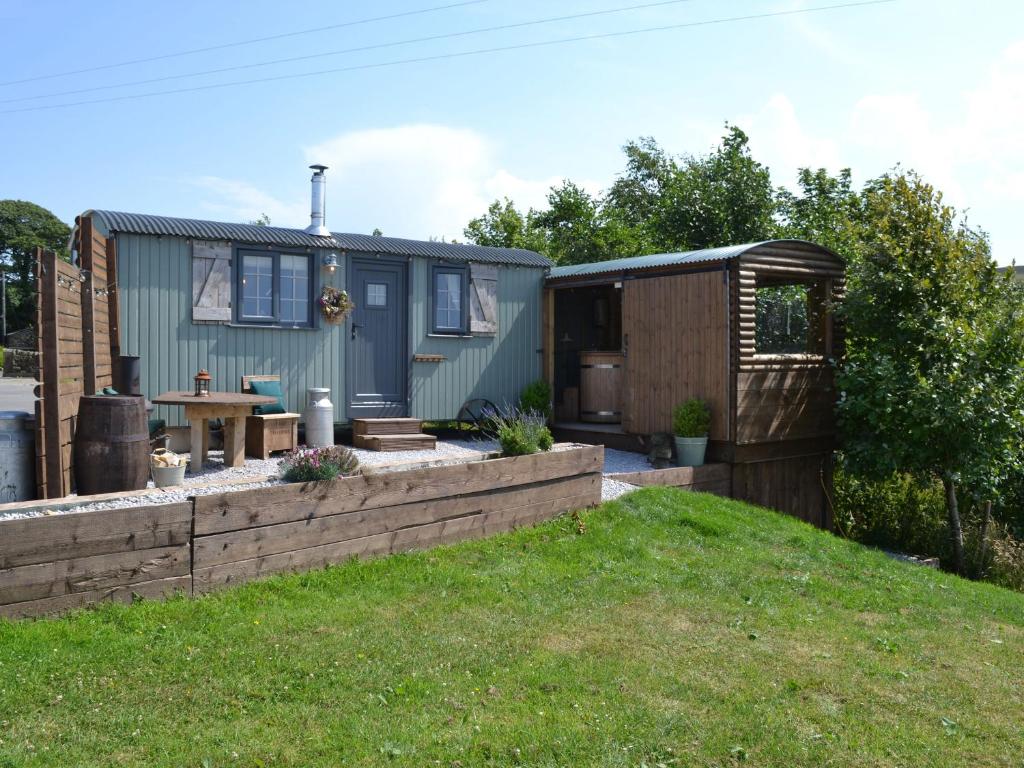 una casita en un patio con una valla en Bracken Hut at Copy House Hideaway en Barnoldswick